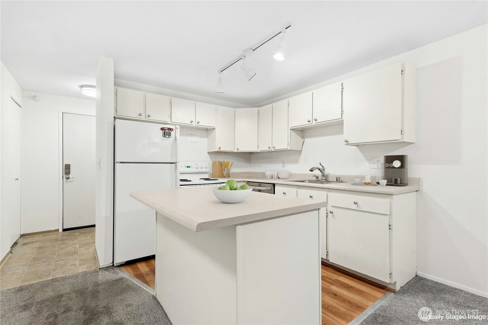 Kitchen area with laminate floors and newer dishwasher.