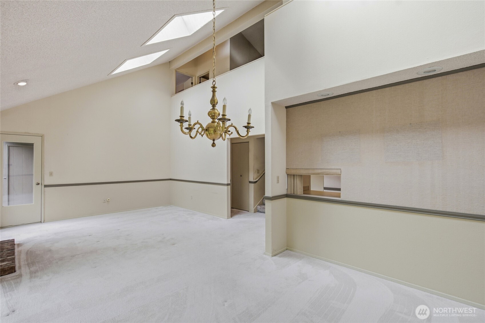 Open, airy dining room with vaulted ceilings and skylights