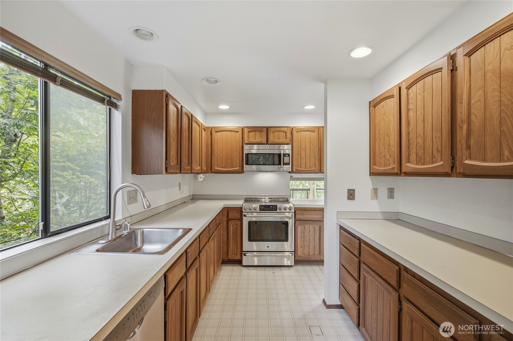 Bright kitchen with window over the sink and forest outlook.
