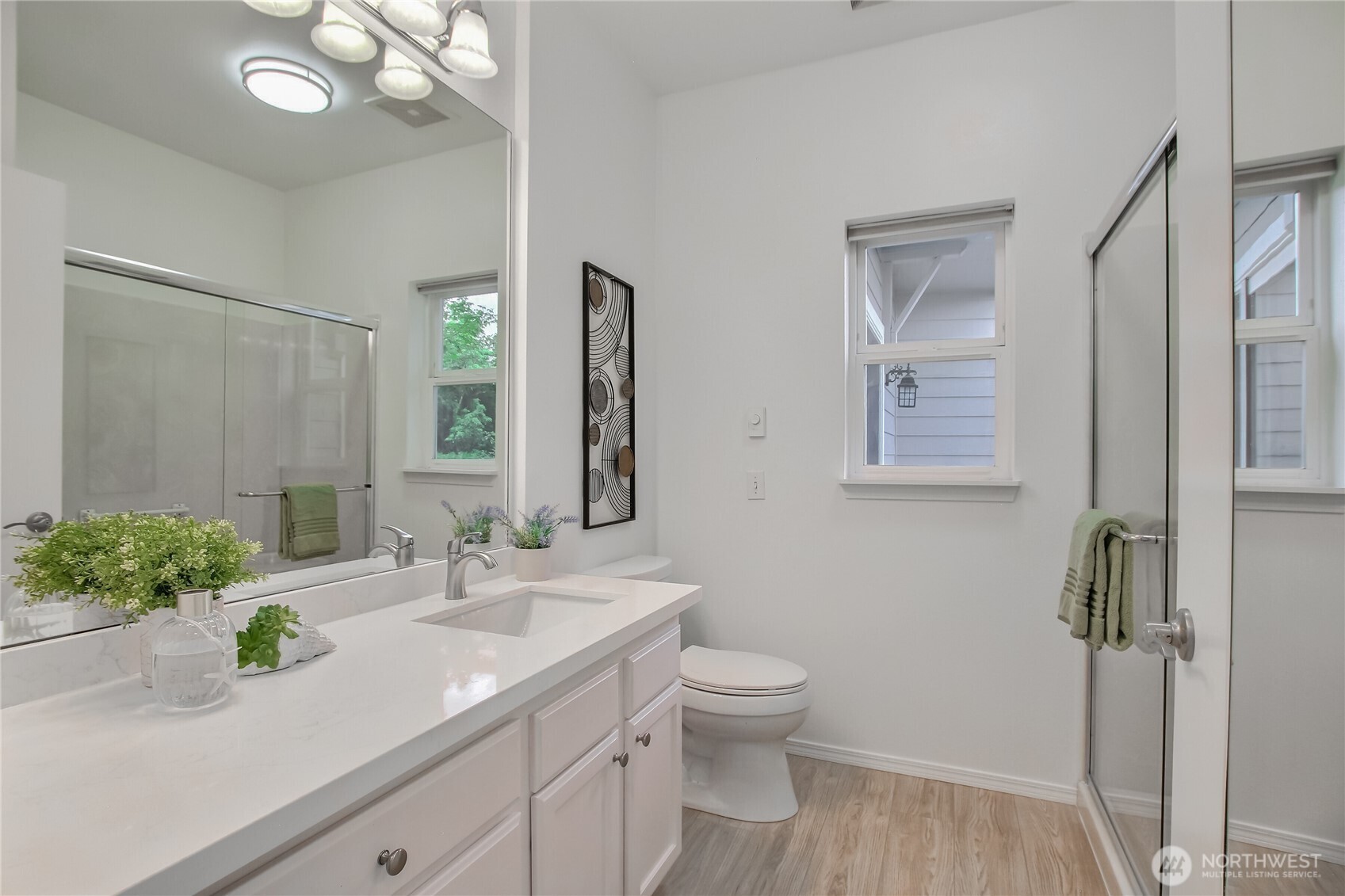 Bathroom with large walk in shower, Quartz countertops and ample storage space.