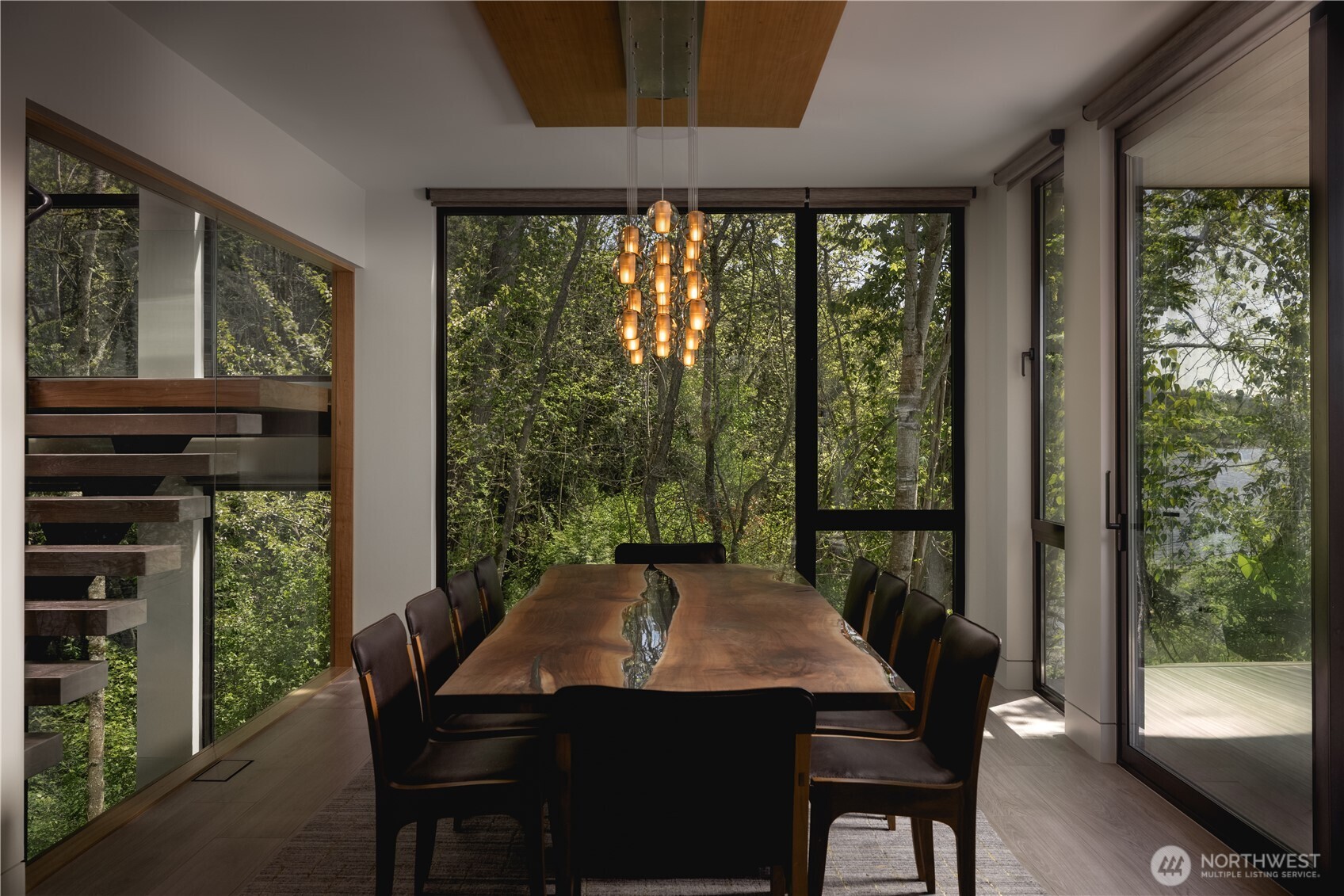 The dining area sits within the landscape, with the terrace extending the experience outward.