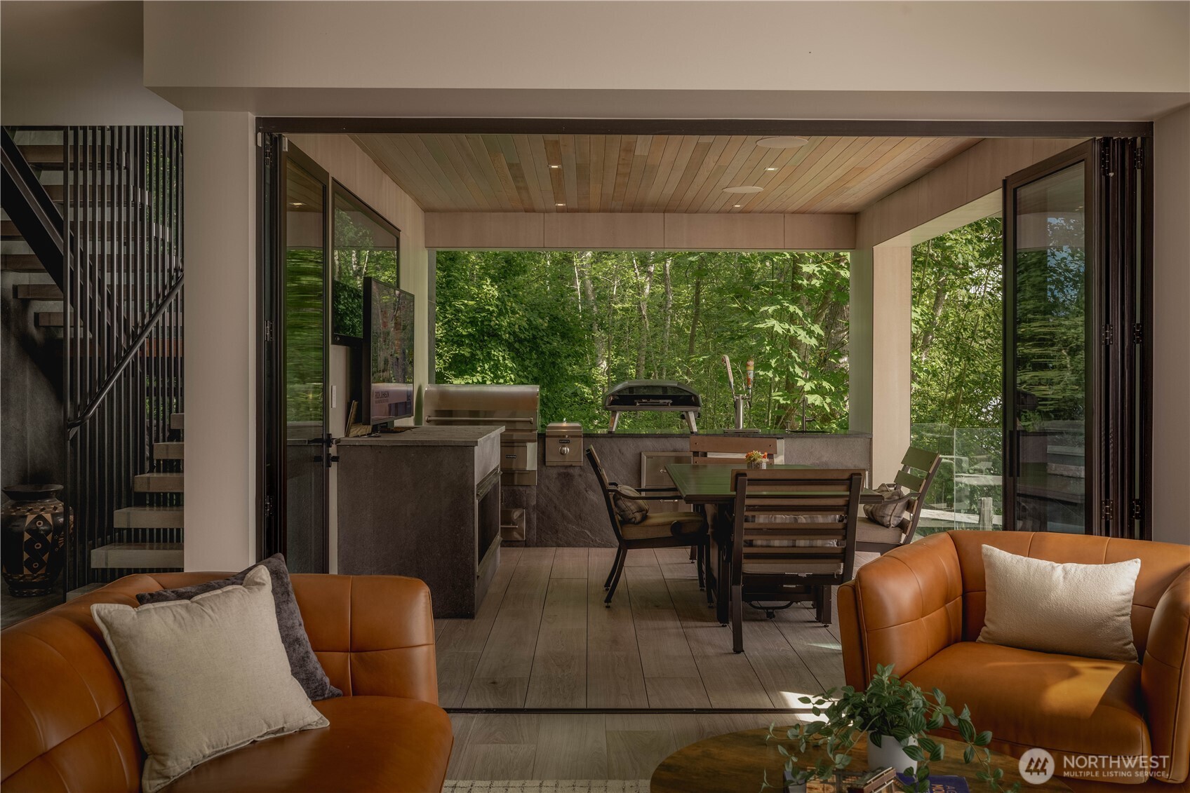NanaWall openings extend to the covered outdoor entertaining area with built-in media integration and outdoor kitchen.