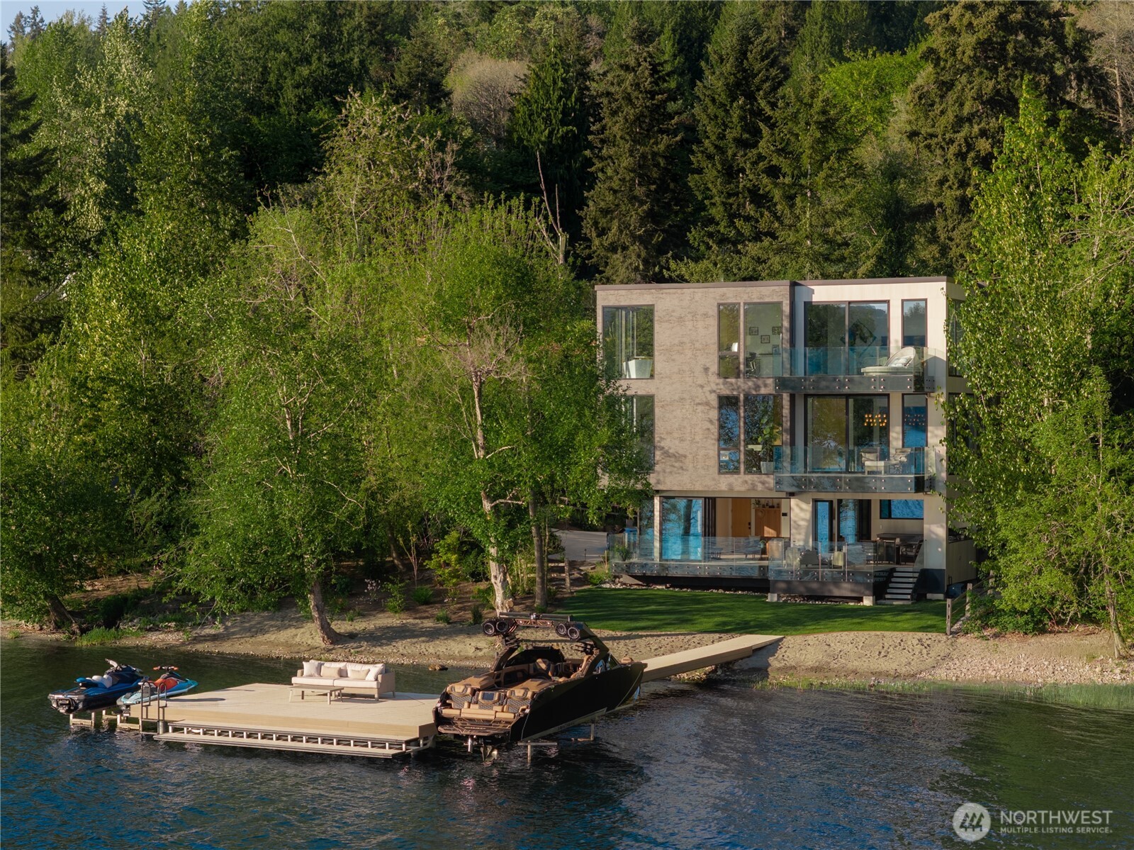 122’ of sandy shoreline extends to an expansive dock with integrated boat and jet ski lifts, designed for effortless time on the water.