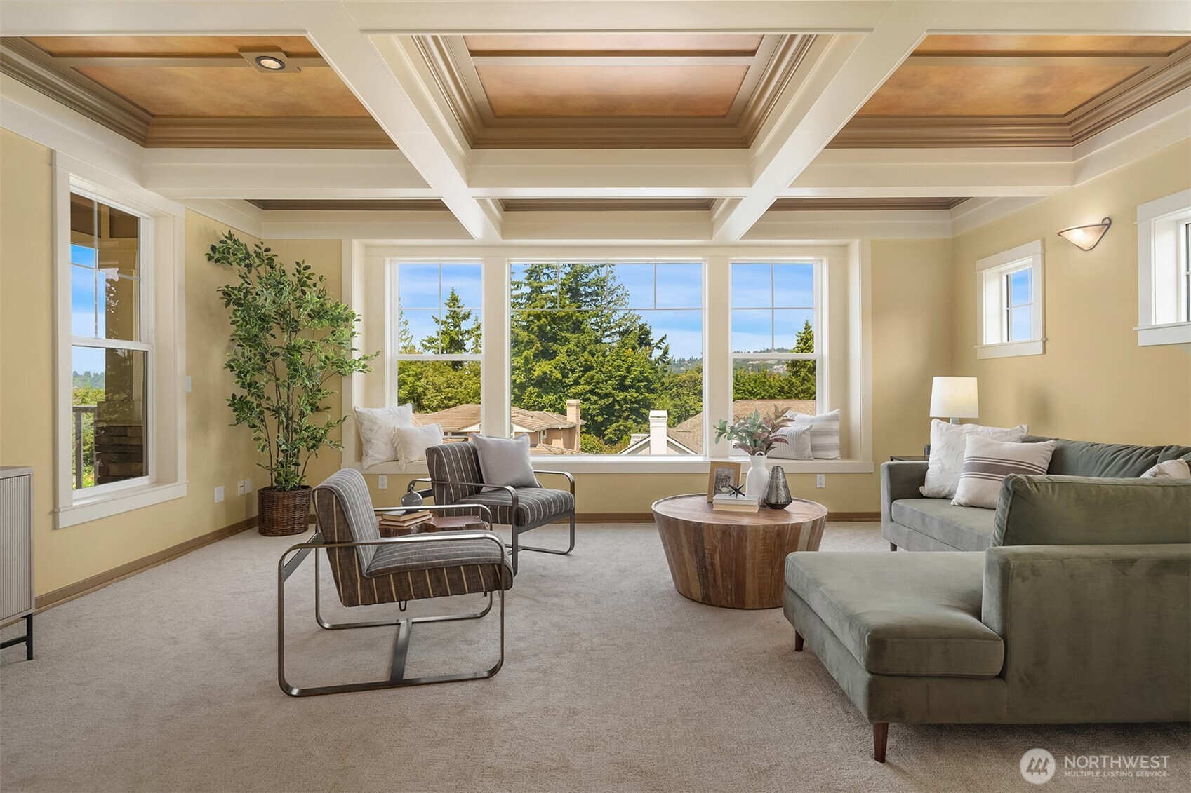 Anchored by a dramatic coffered ceiling and walls of windows, the family room is filled with natural light and captures peaceful glimpses of Lake Washington, the Bellevue skyline, surrounding mountains, and territorial vistas.