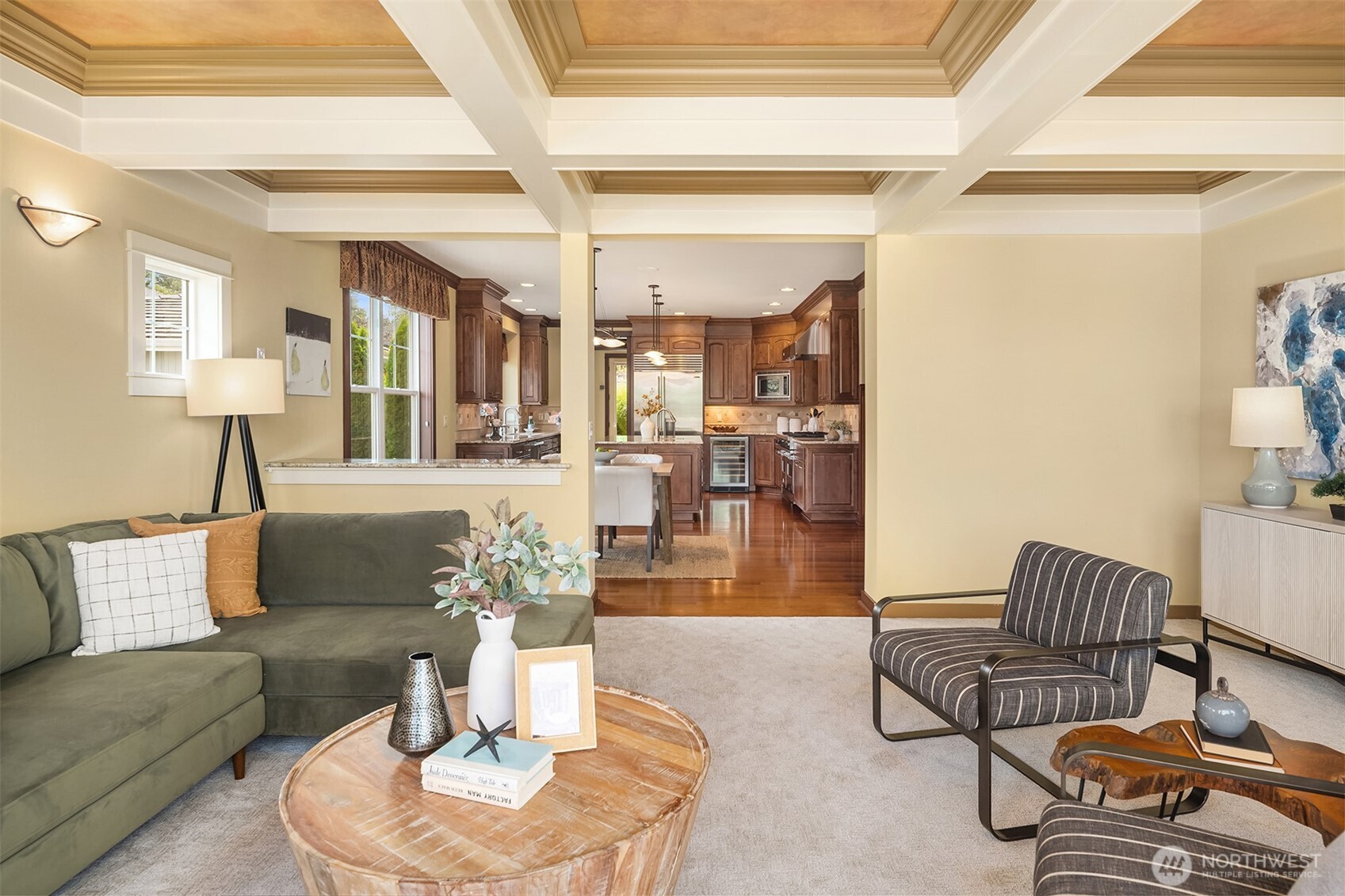 Anchored by a dramatic coffered ceiling, the spacious great room flows effortlessly into the chef's kitchen, creating the perfect gathering space.