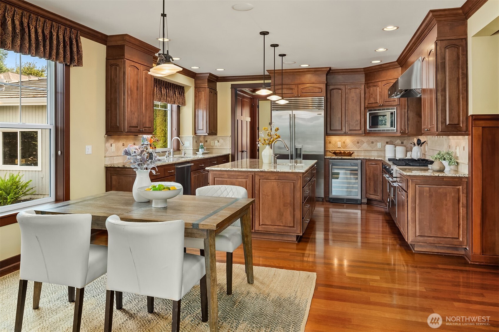 A generous kitchen and casual dining area create an easy everyday hub, with ample workspace, abundant storage, and a natural connection to the family room beyond.