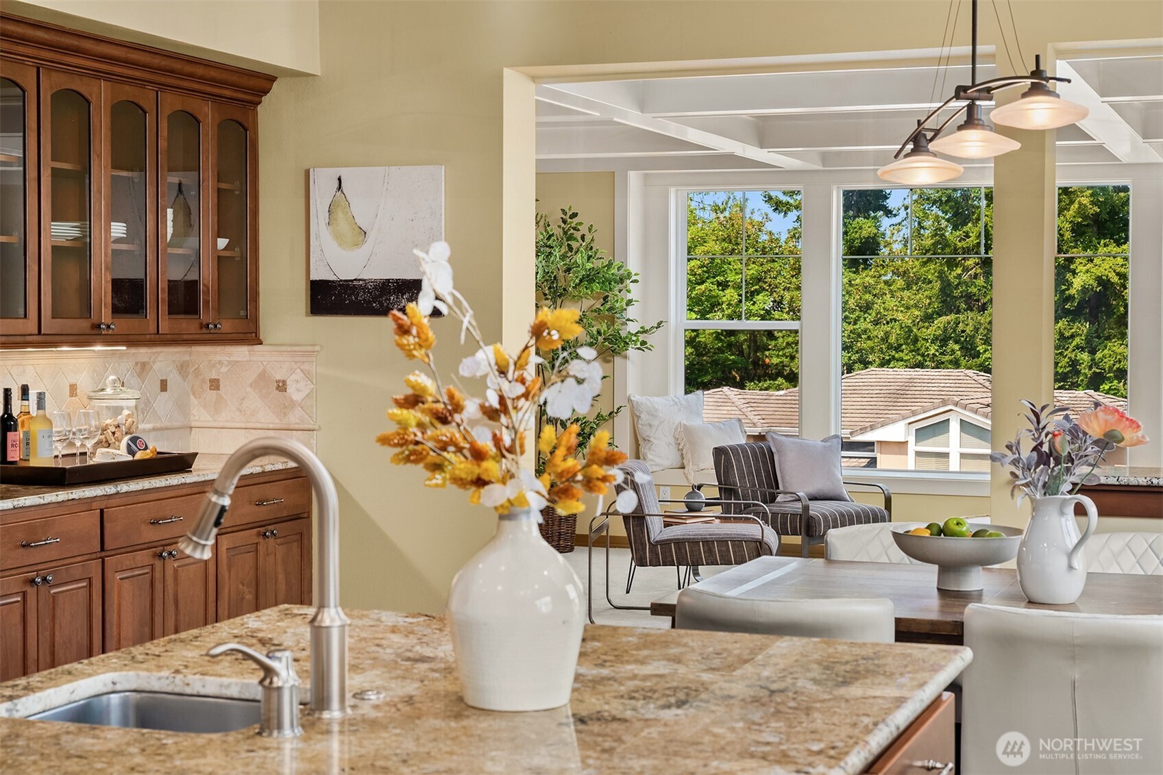 Whether preparing dinner or entertaining guests, the chef's kitchen remains connected to the family room, where oversized windows frame peek-a-boo views and bring the outdoors in.