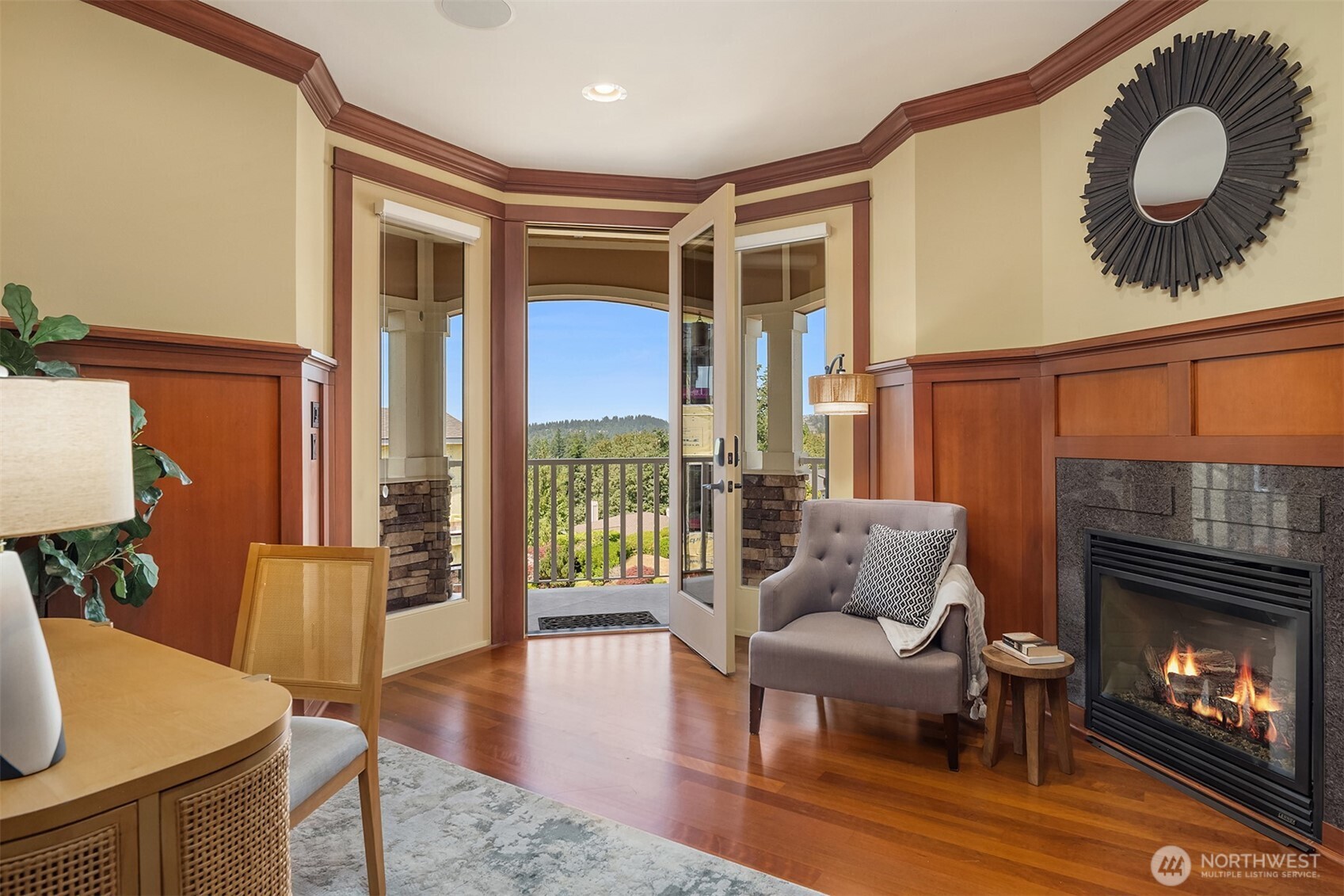 A private executive office offers an inspiring work-from-home setting, complete with a fireplace, rich millwork, and direct access to the expansive wraparound deck for fresh air and peaceful breaks throughout the day.