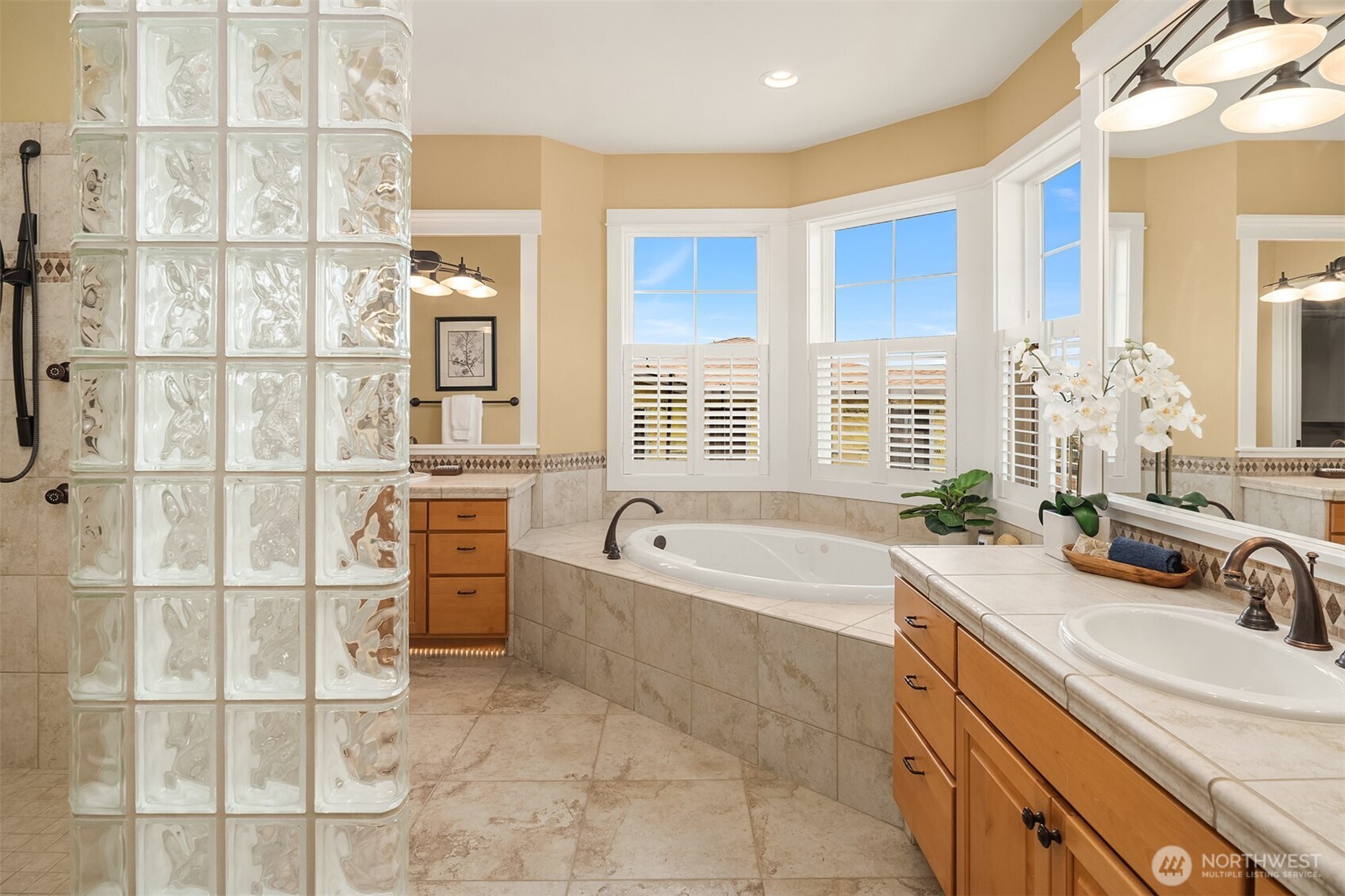 Designed with a spa-inspired sensibility, the primary bath features dual vanities, a soaking tub, oversized walk-in shower, and abundant natural light.