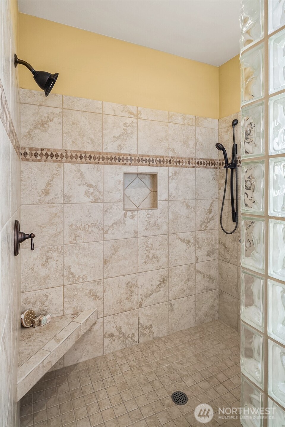 Spa-worthy finishes include an expansive walk-in shower accented by glass-block walls that fill the space with soft natural light.