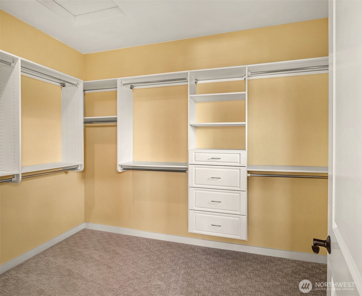 Designed for effortless organization, the expansive walk-in closet features built-in cabinetry, drawers, and abundant storage.