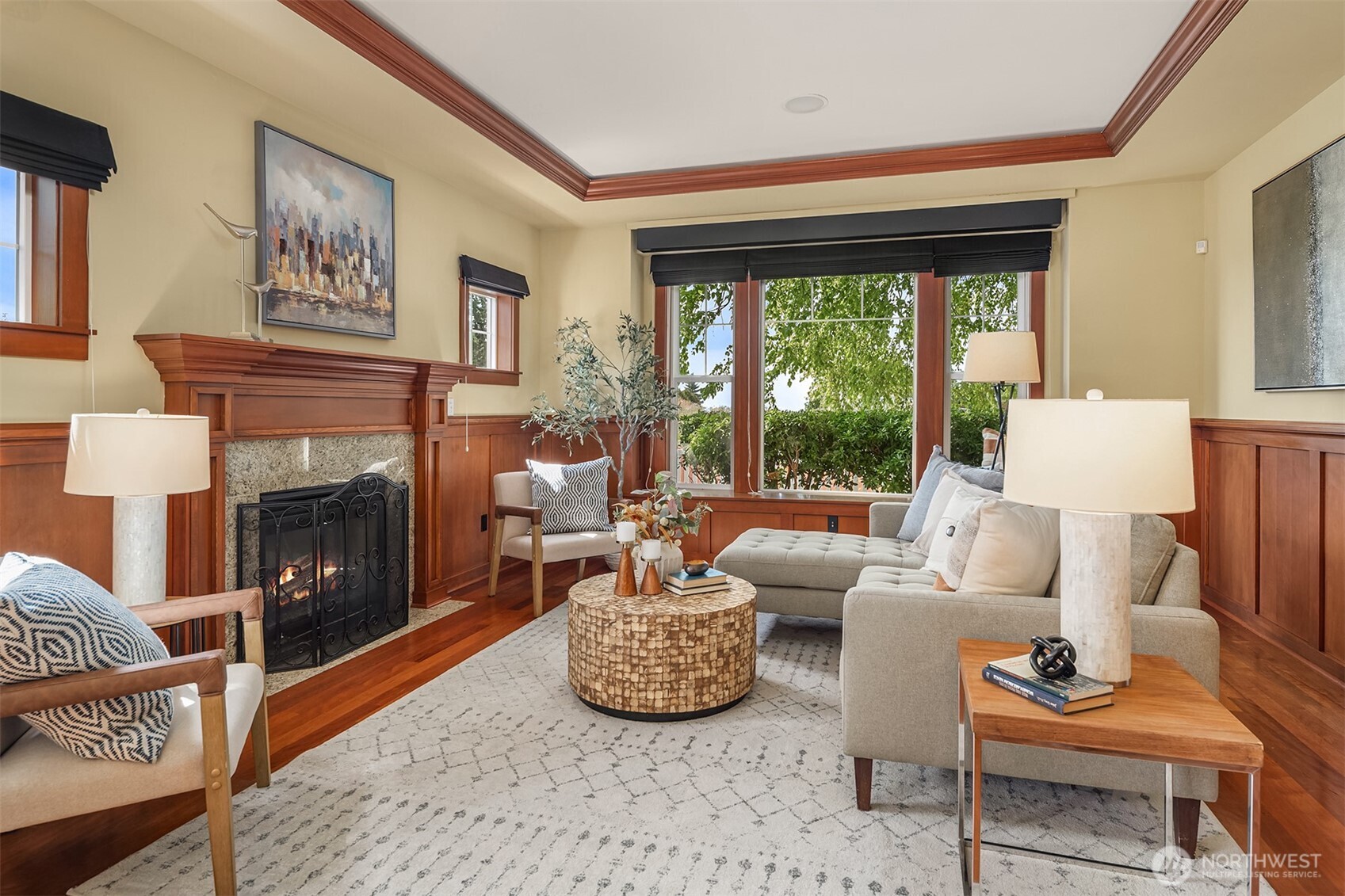 Rich millwork, a gas fireplace, and walls of windows create a warm, inviting gathering space filled with natural light and timeless Craftsman character.