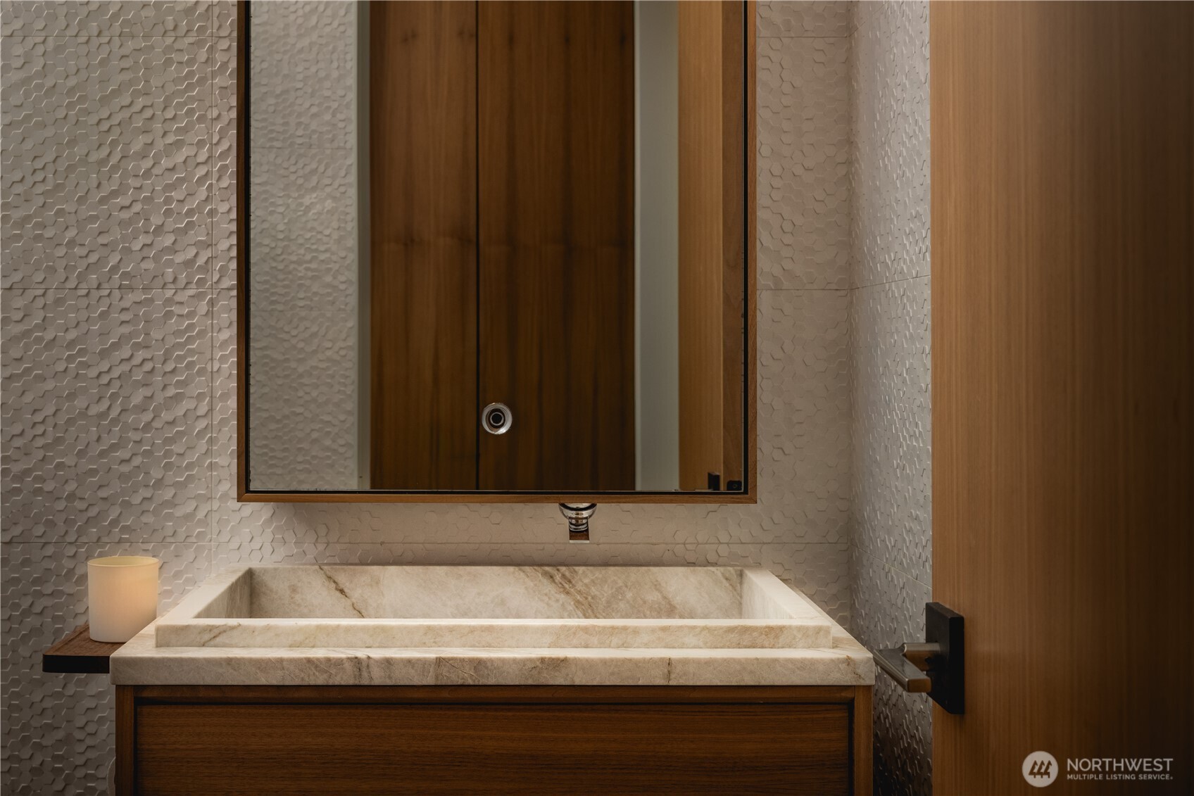 The main level powder room carries the home’s restrained material palette with consistency.