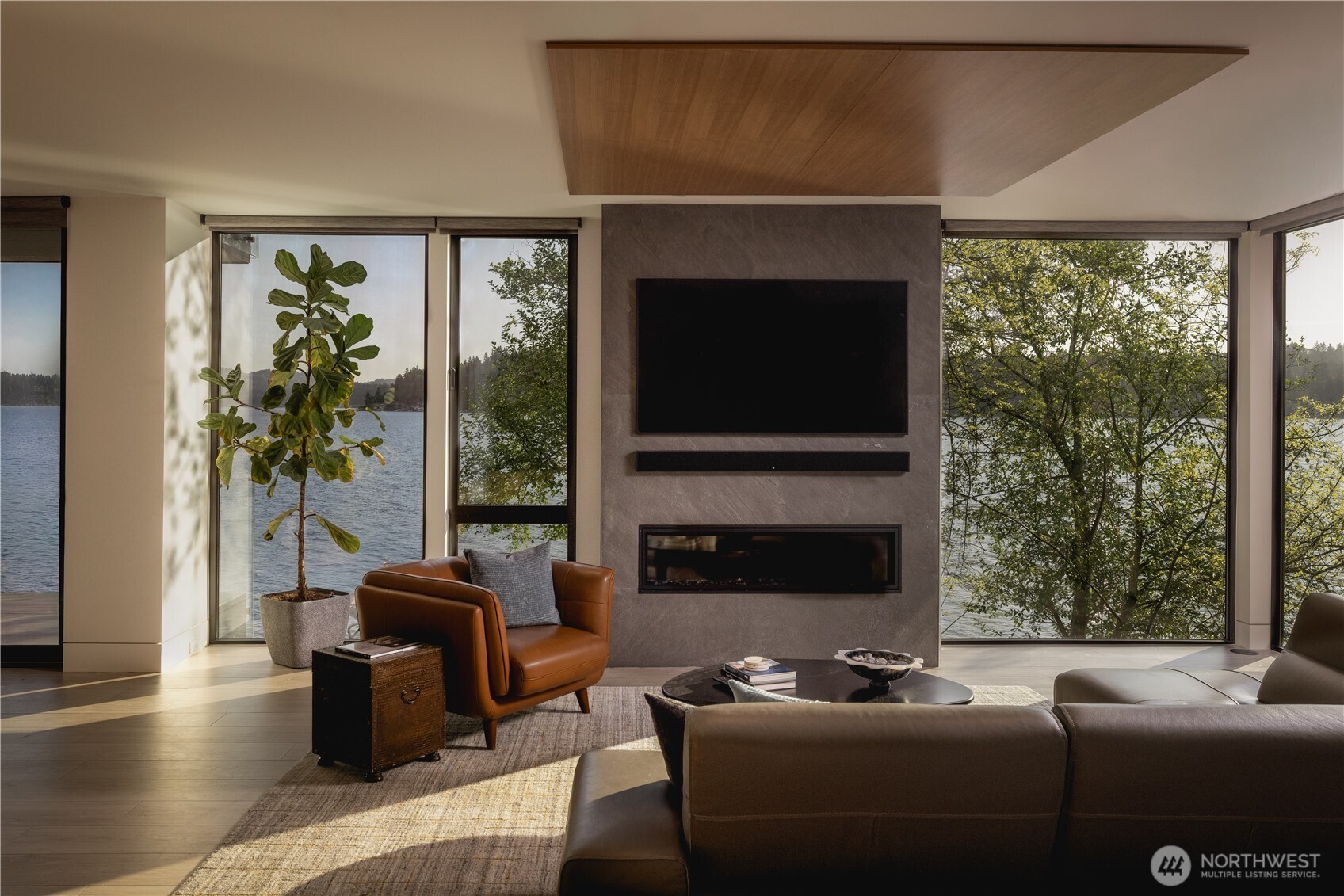 Floor-to-ceiling glass frames water, canopy, and changing light, bringing the outdoors naturally into daily life.