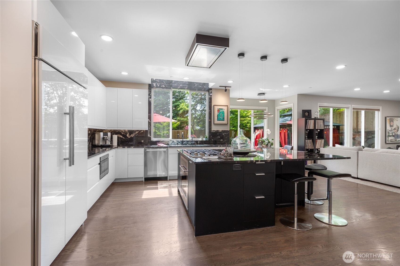 Designer kitchen featuring sleek, full-height custom cabinetry, dramatic stone surfaces, Wolf and Sub-Zero appliances, and a statement island with custom lighting—ideal for entertaining and everyday living.”