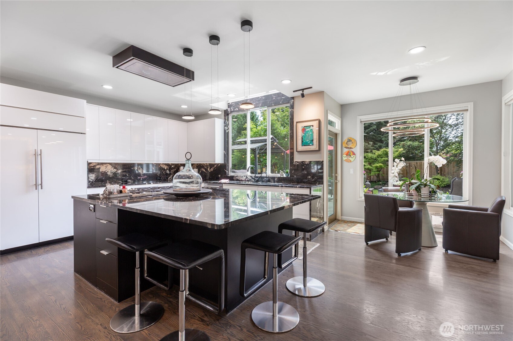 Stunning chef’s kitchen with sleek quartz countertops, oversized waterfall island, premium appliances, and designer lighting.