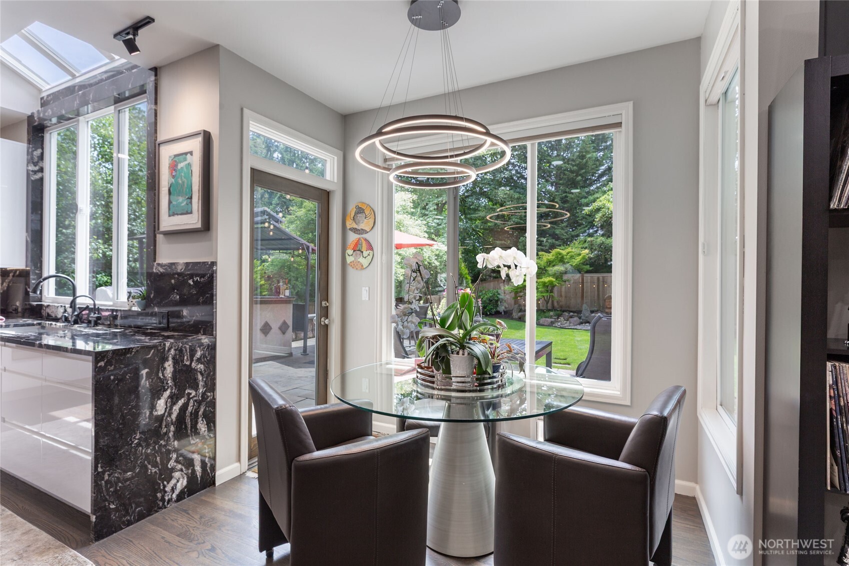 Bright dining nook adjacent to the kitchen, surrounded by windows and overlooking the private backyard—perfect for casual meals and indoor-outdoor flow