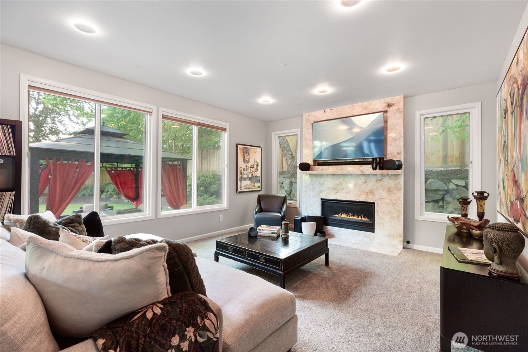 Backlit fireplace adds a dramatic focal point to this bright, comfortable space overlooking the backyard.