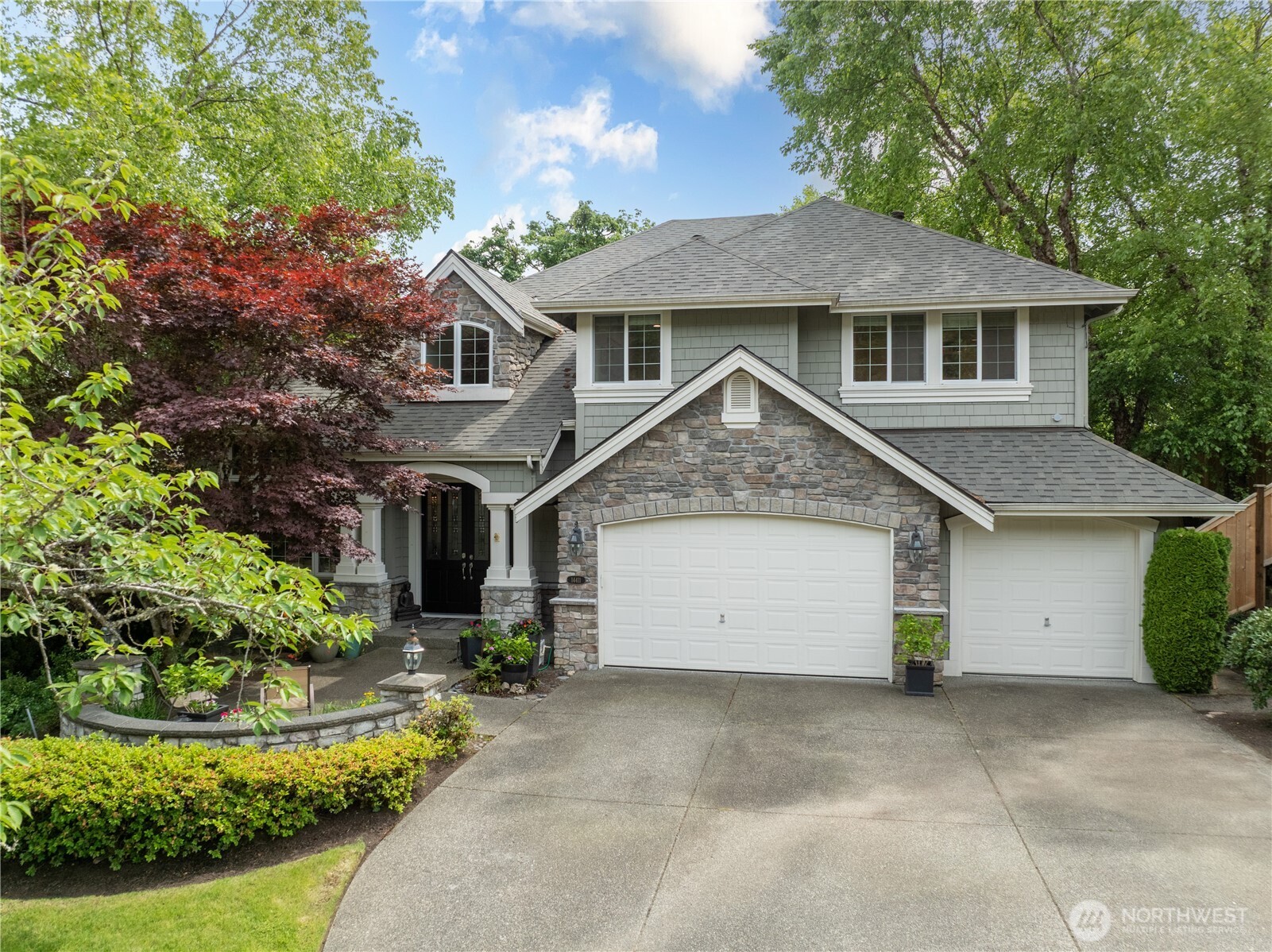 Beautifully maintained exterior with stone accents, generous driveway, and welcoming entry—nestled on a quiet street in the sought-after Highlands at Newcastle community