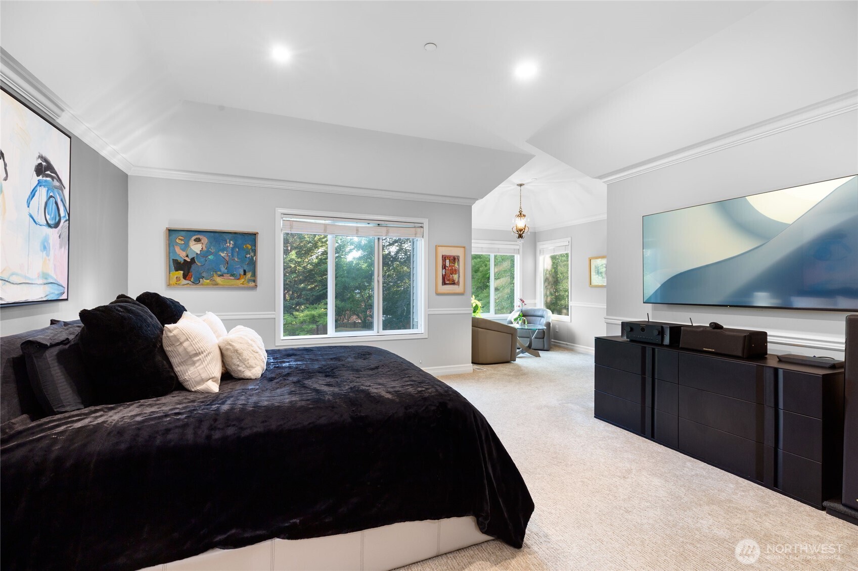Light-filled sitting area within the primary suite with large windows and lush views.