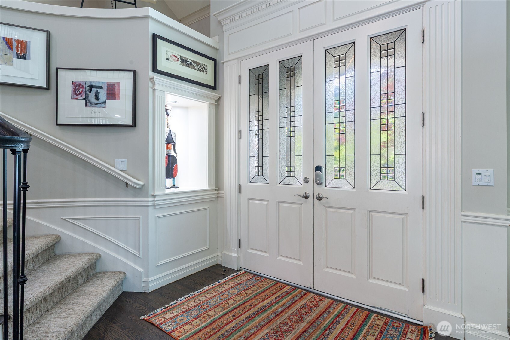 Inviting entry with decorative glass double doors, classic millwork, and a built-in art alcove—creating a refined and memorable first impression.