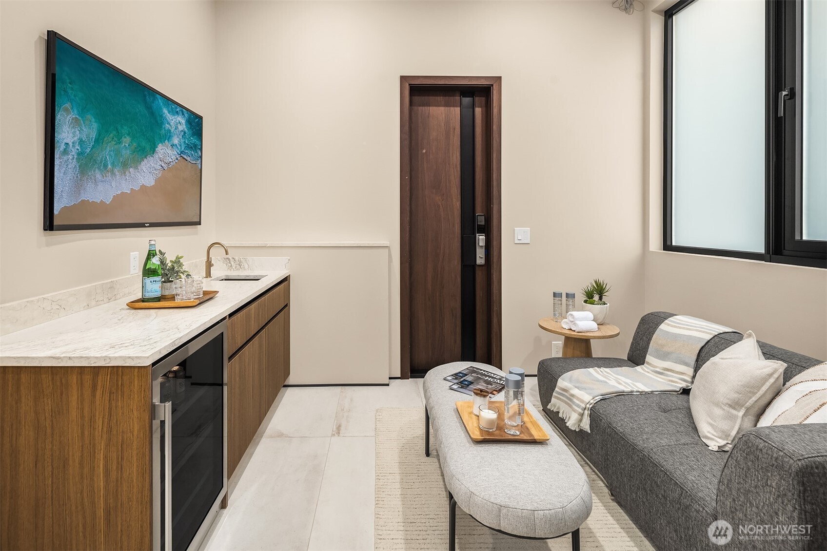 Lower level wellness room to relax after your sauna + cold plunge! Featuring a wet bar, outside access and a whole house water filtration system