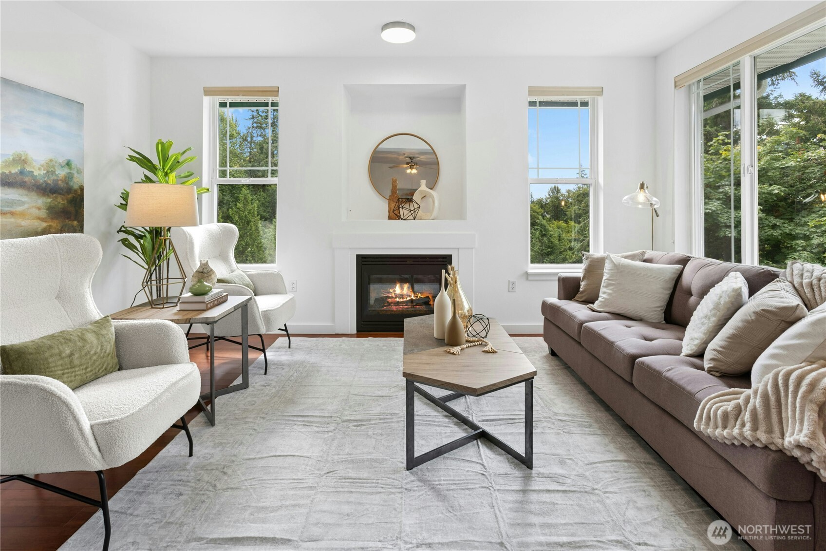 Light-filled living room surrounded by windows and peaceful treetop views