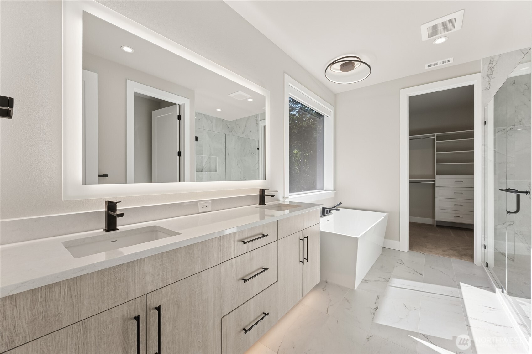 The luxurious primary bathroom includes a spacious dual sink vanity, designer finishes and abundant cabinetry.