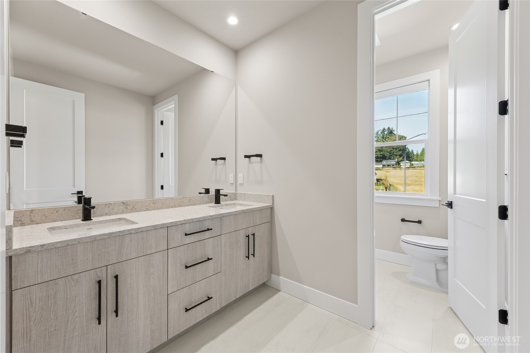 A dual sink vanity, contemporary fixtures and a great amount of storage space make this upstairs bathroom both stylish and functional.