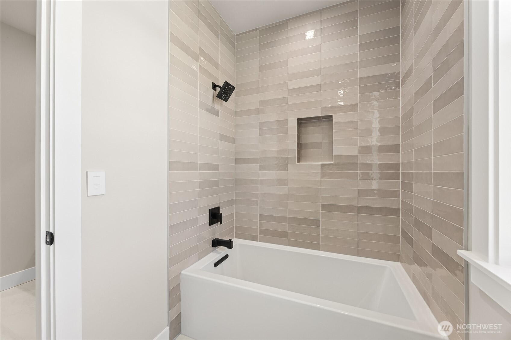 A beautifully tiled tub/shower behind a separate door for privacy and functionality.