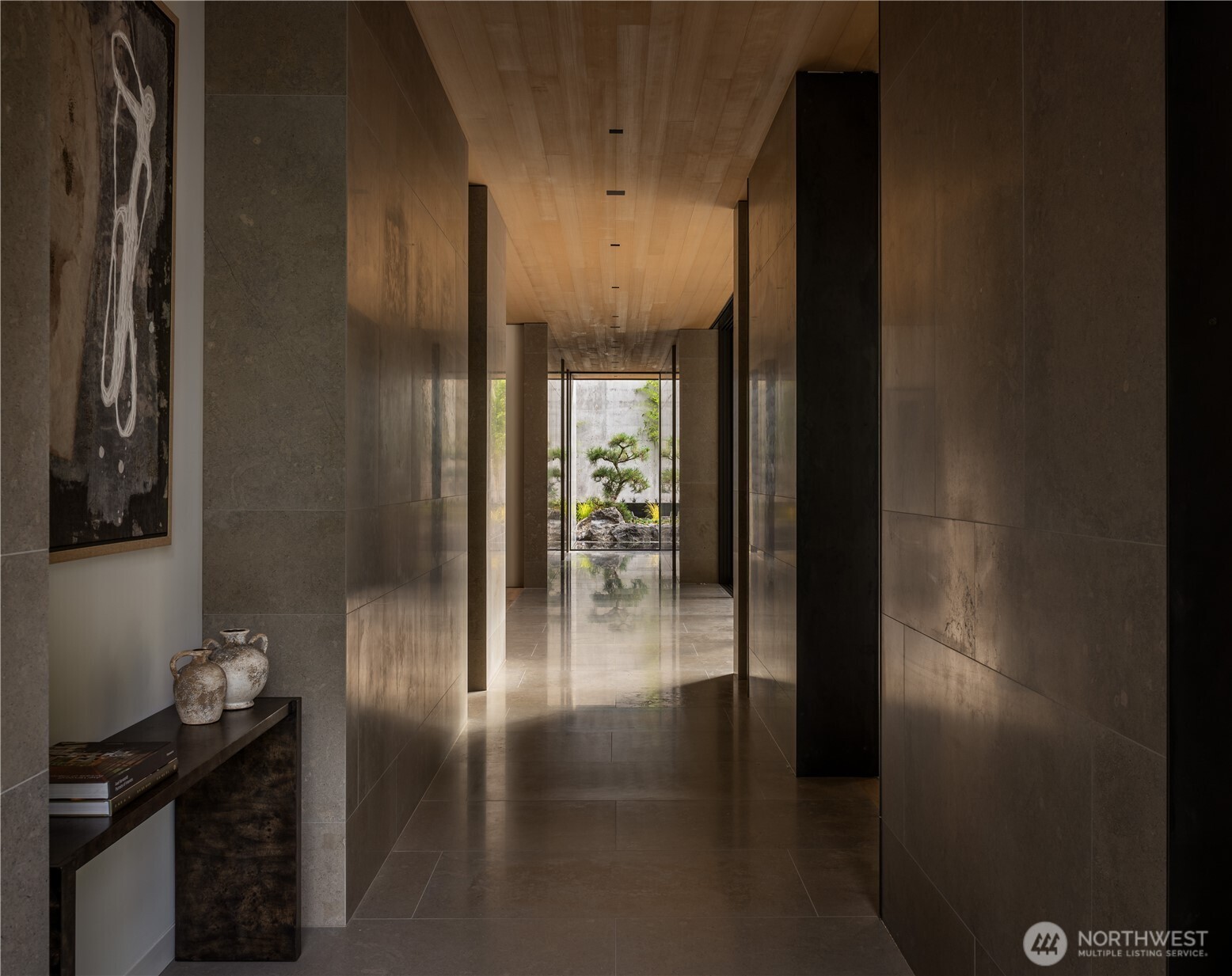 A glass-lined gallery, 10-foot walnut door and Faune limestone flowing from exterior to interior establish a quiet, Japanese-influenced material language.