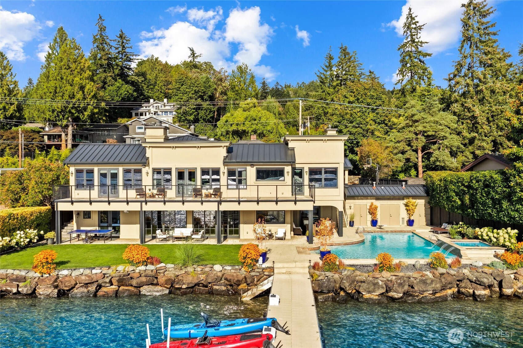 Southwest-facing waterfront estate in coveted Holmes Point capturing breathtaking views of Lake Washington, the Olympic Mountains, Mount Rainier, and endless golden sunsets from 113 feet of prime waterfrontage
