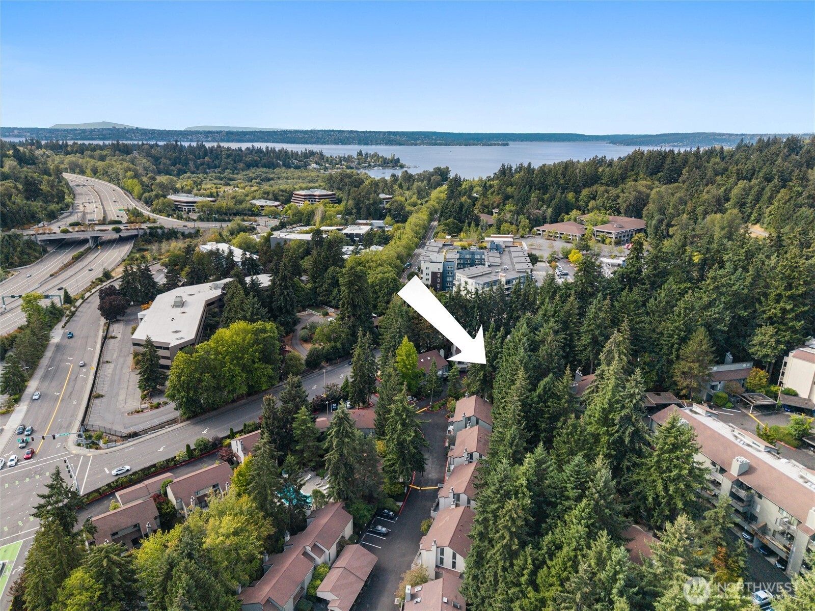 Surrounding evergreens, nearby lake, and proximity to major roads and freeway access.
