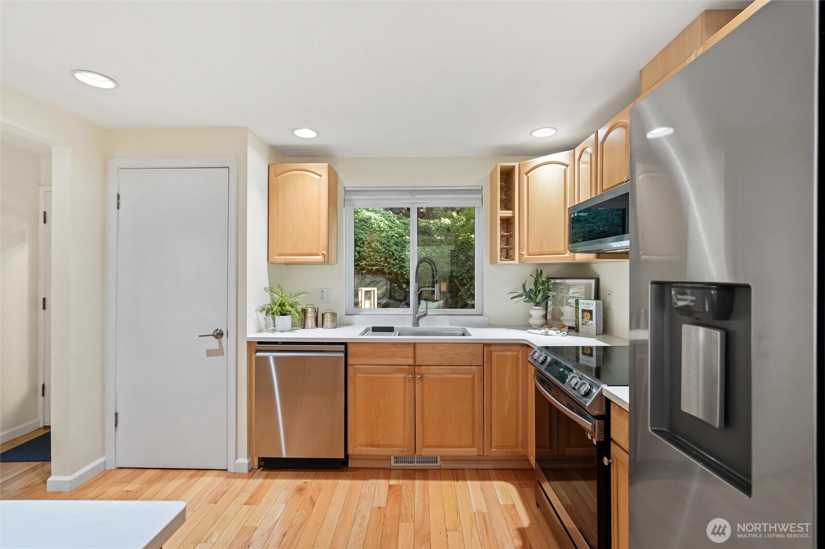 Kitchen with large window, stainless steel appliances, and clean, modern finishes