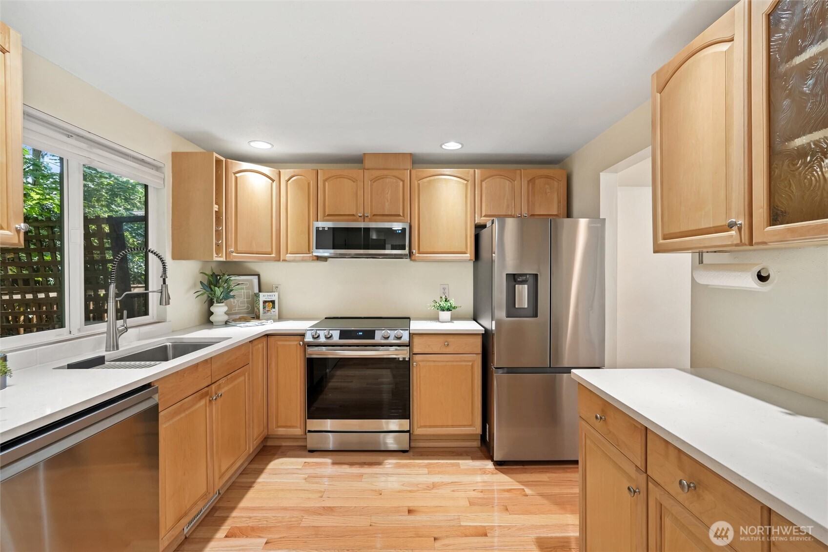Bright transitional area featuring hardwood flooring and modern built-ins