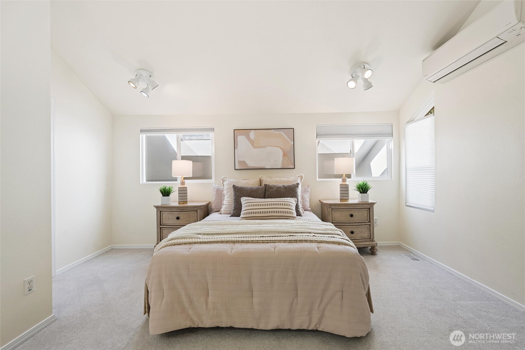 Light-filled primary bedroom with connected vanity area and walk-in closet.