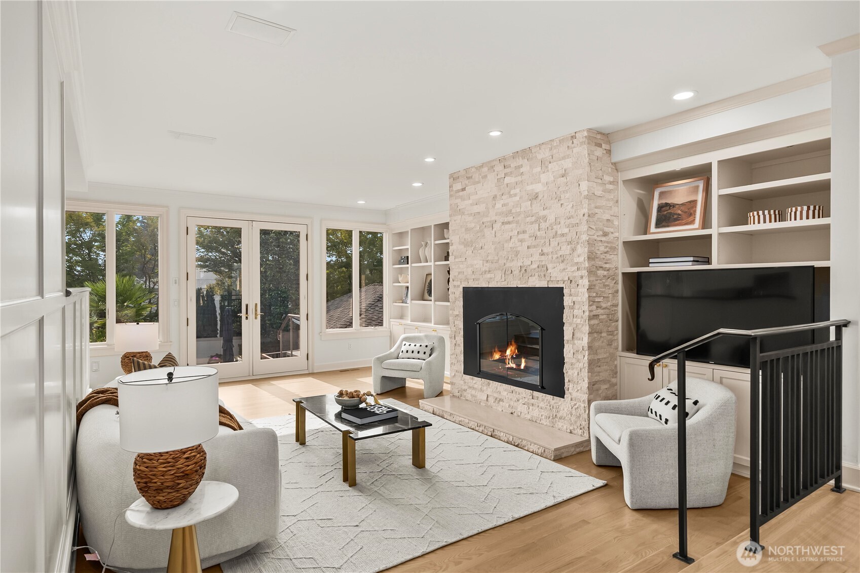 Family room next to the kitchen with new resurfaced stone fireplace, custom built-ins, hardwood floors, and French doors to outdoor living.