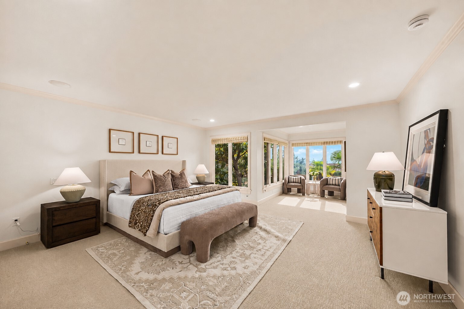 Spacious primary retreat with a private sitting area, abundant natural light, and serene garden views