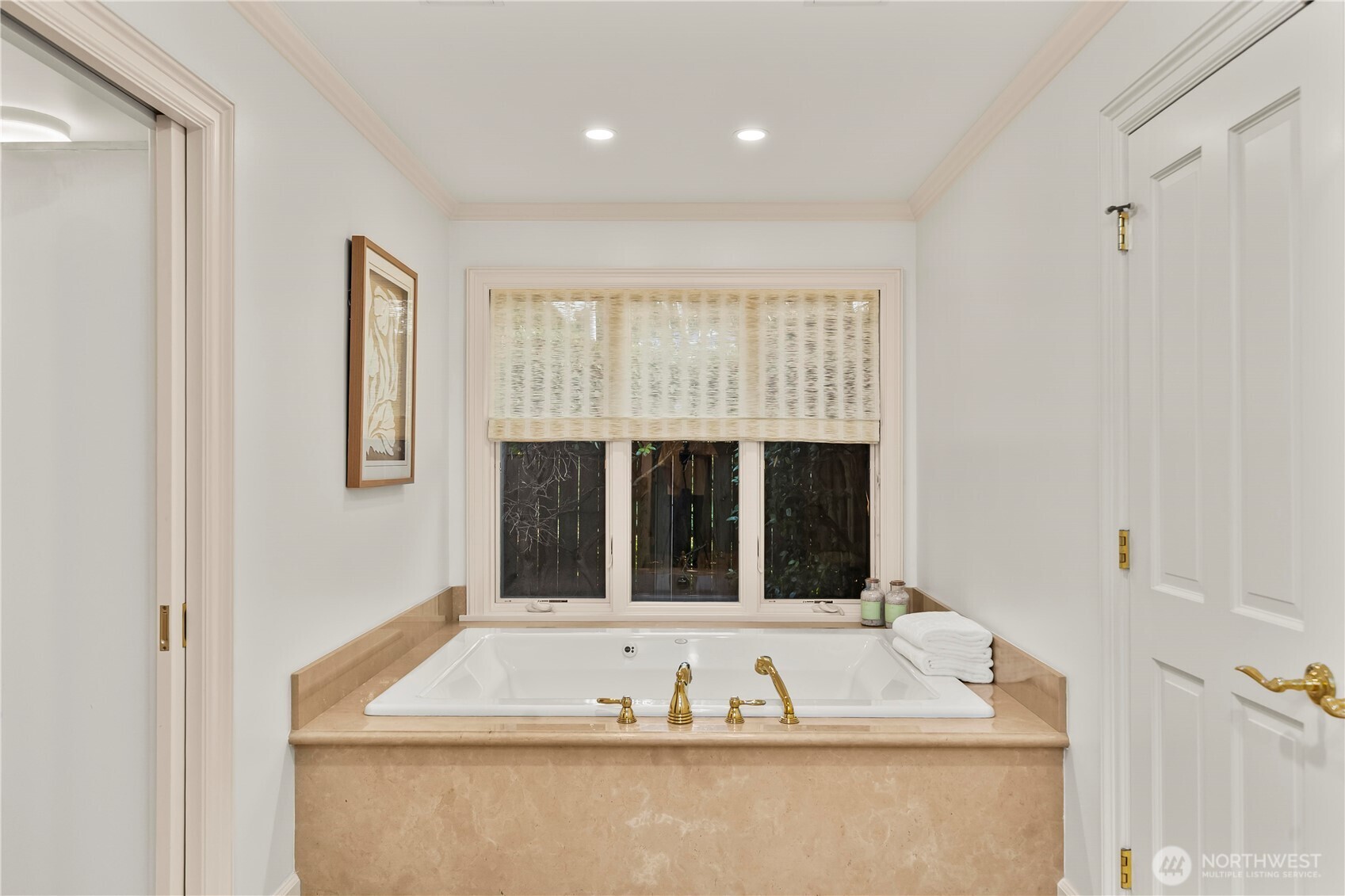 Relaxing oversized soaking tub with elegant stone surround and a peaceful garden outlook