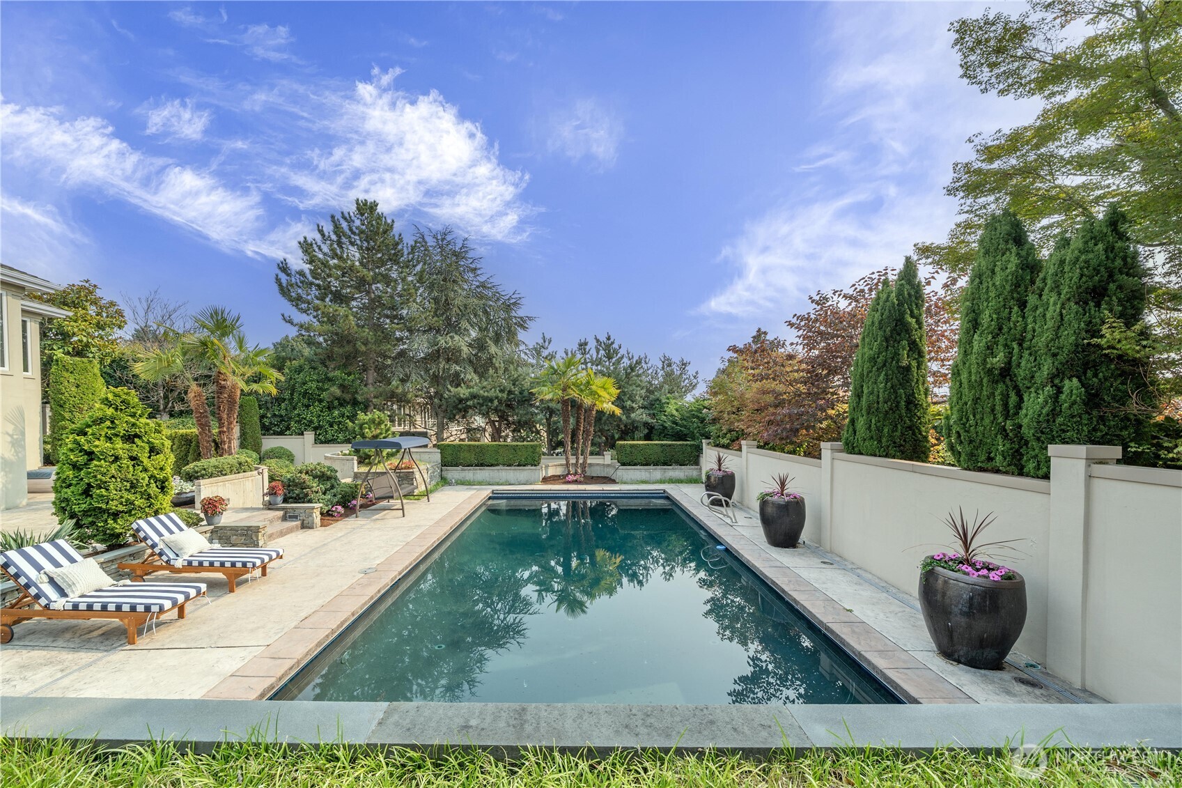 A serene backyard retreat surrounded by lush, mature landscaping—perfect for swimming, relaxing, and outdoor entertaining.