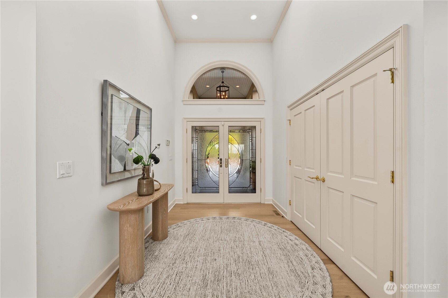 A dramatic foyer creates an elegant first impression, highlighted by distinctive decorative glass double doors