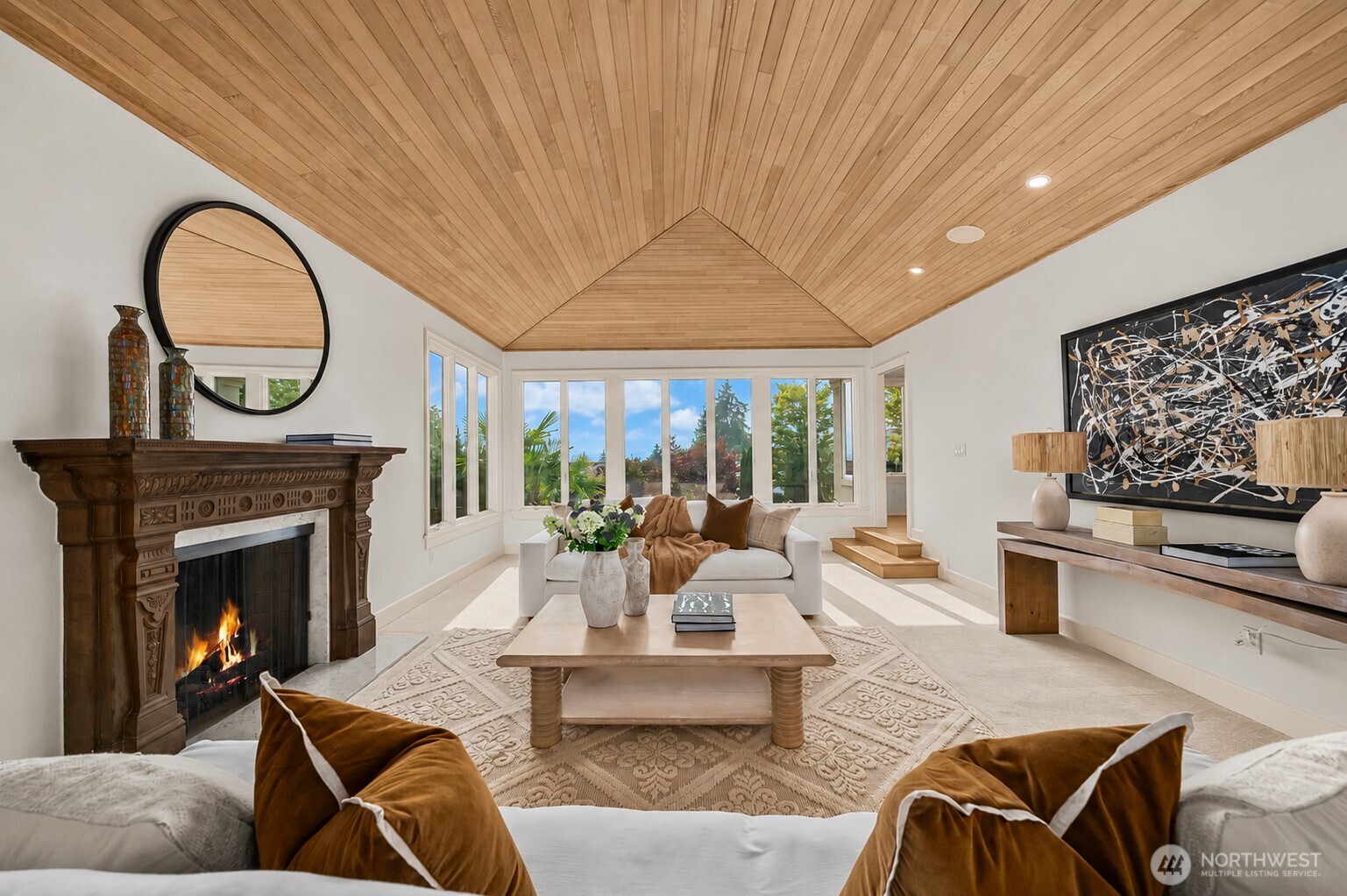 A dramatic wood-paneled vaulted ceiling brings warmth and architectural character to this light-filled living room.