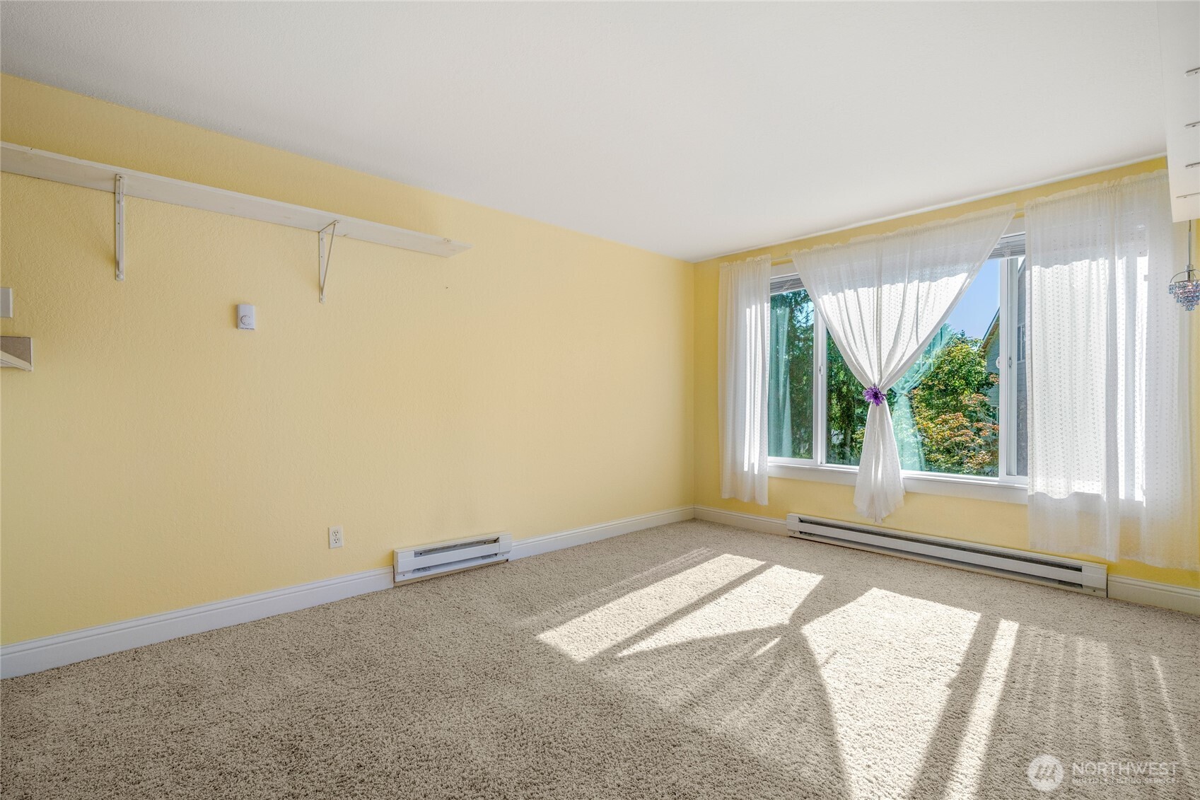 Additional unfurnished view of the studio living area and southwest-facing windows.