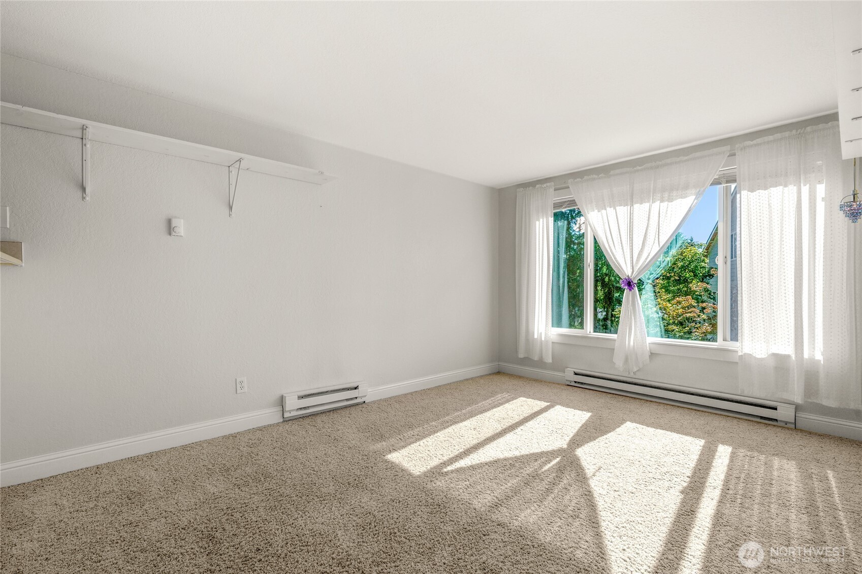Unfurnished studio living area with southwest-facing windows and natural light.