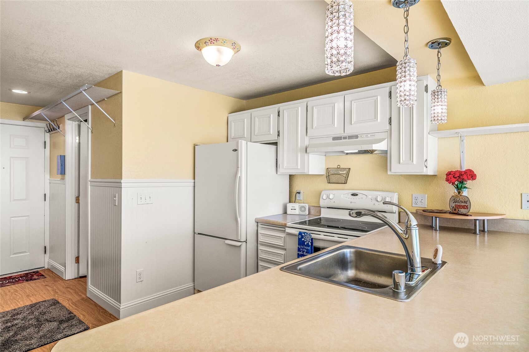 Kitchen with cabinetry, appliances, counter space, and breakfast bar.