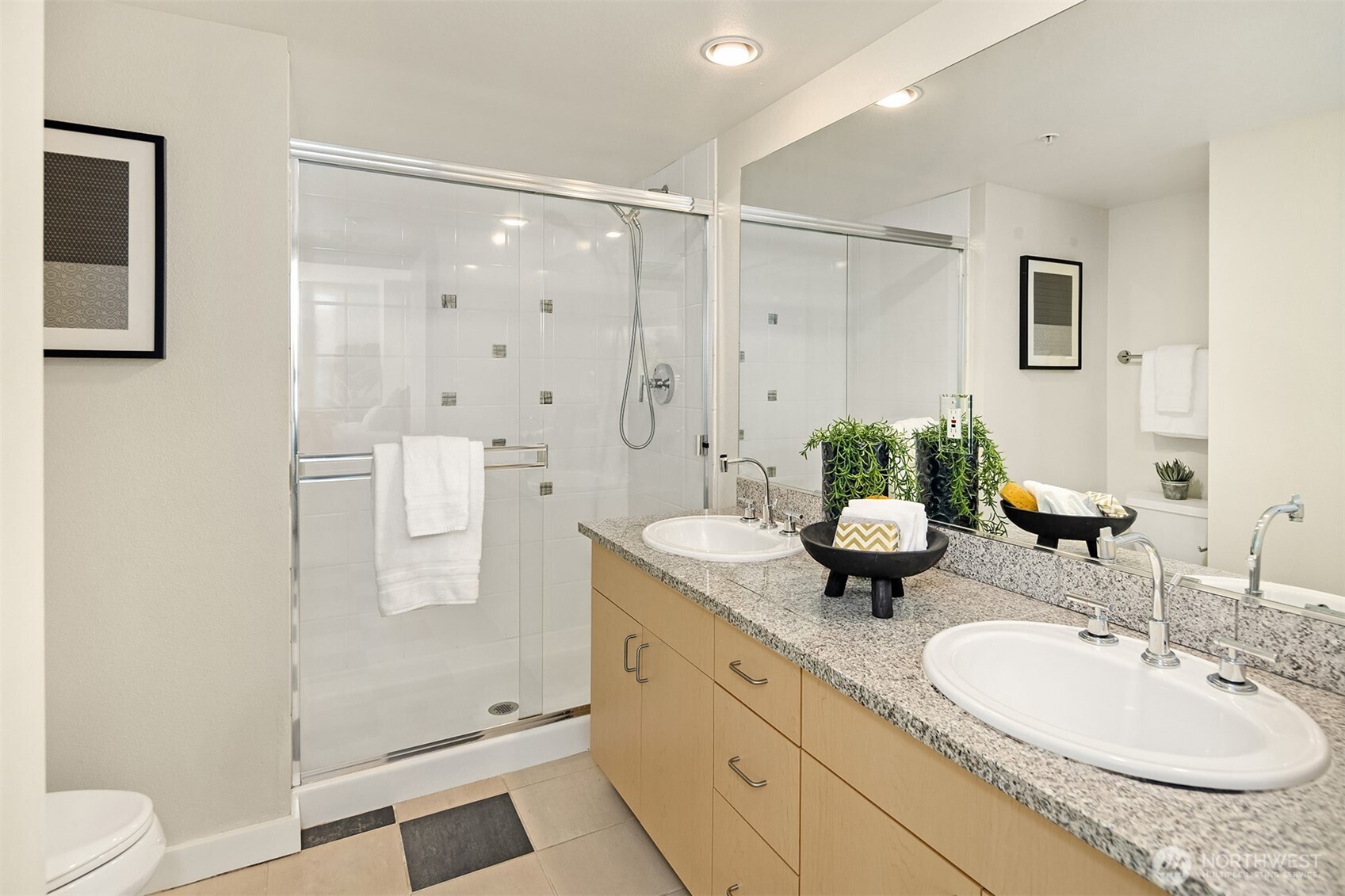 The primary bedroom's roomy ensuite bathroom features a double sink vanity and a custom-tiled shower.