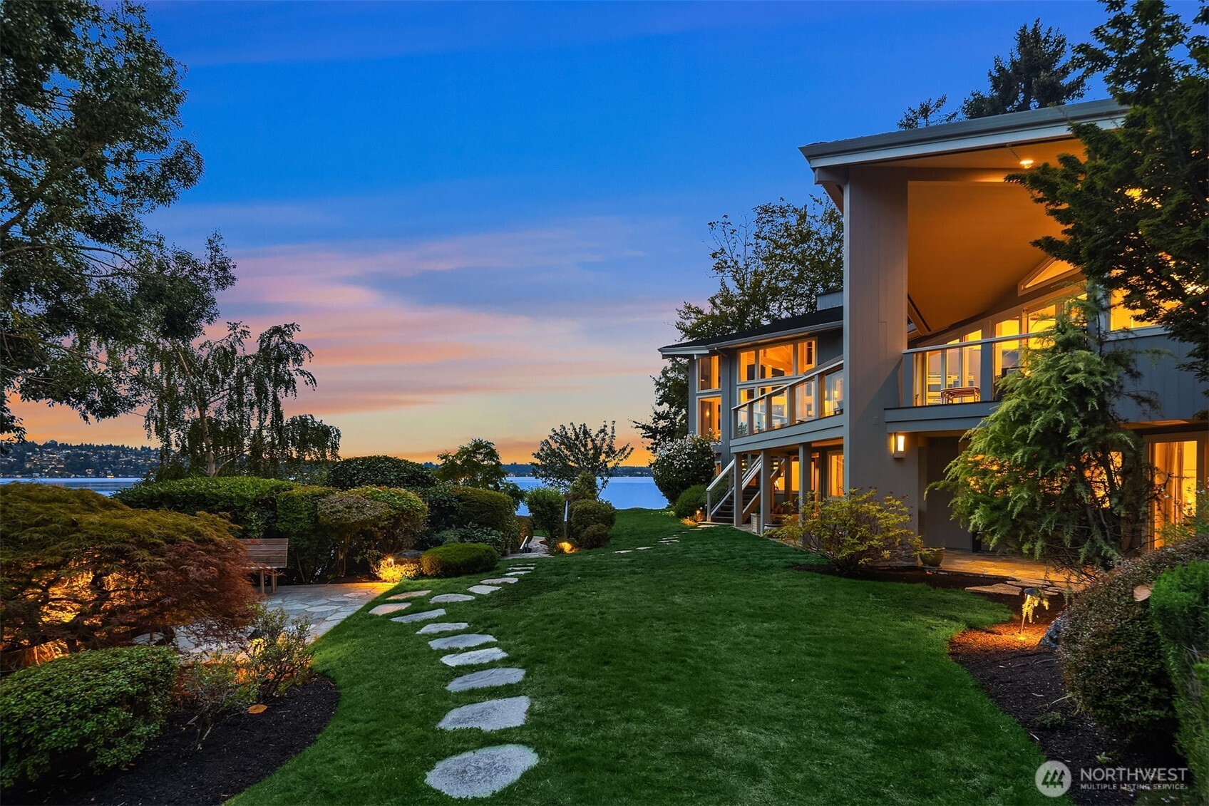 Multiple outdoor spaces to gather and entertain including a level play lawn, and stone paths to the private firepit, waterfront peninsula patio, private dock and steps down into the water & pebble bottom.