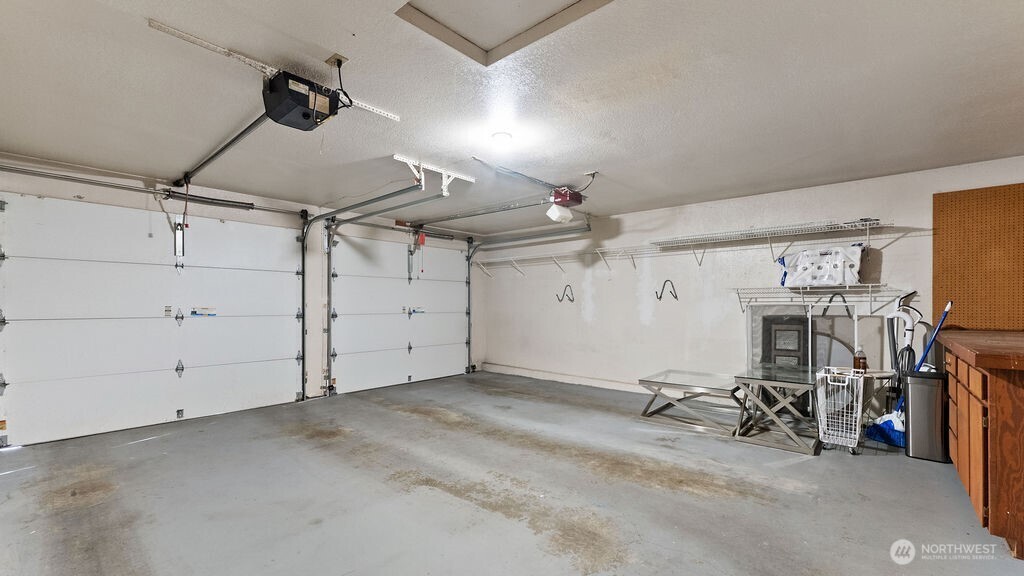 Large 2 car garage with double doors and two steps out the front door.