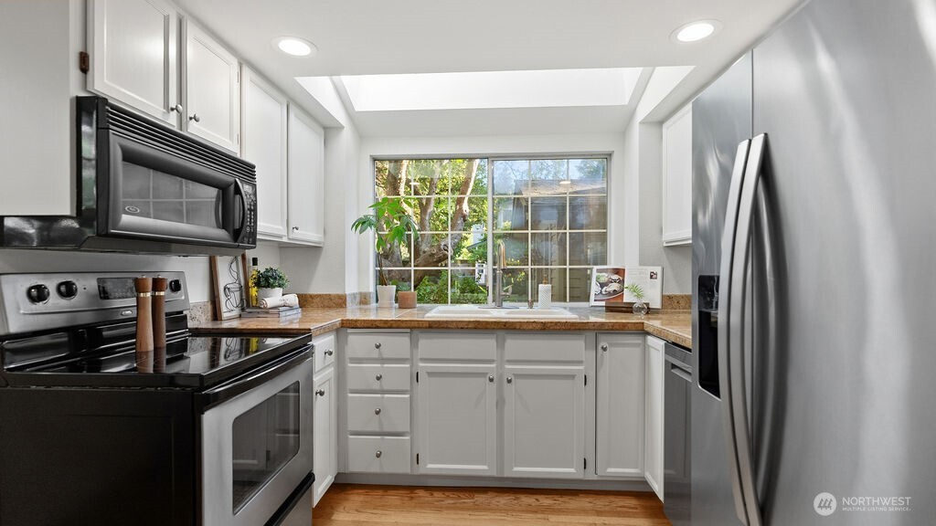 Sunny kitchen with stainless steel appliances.