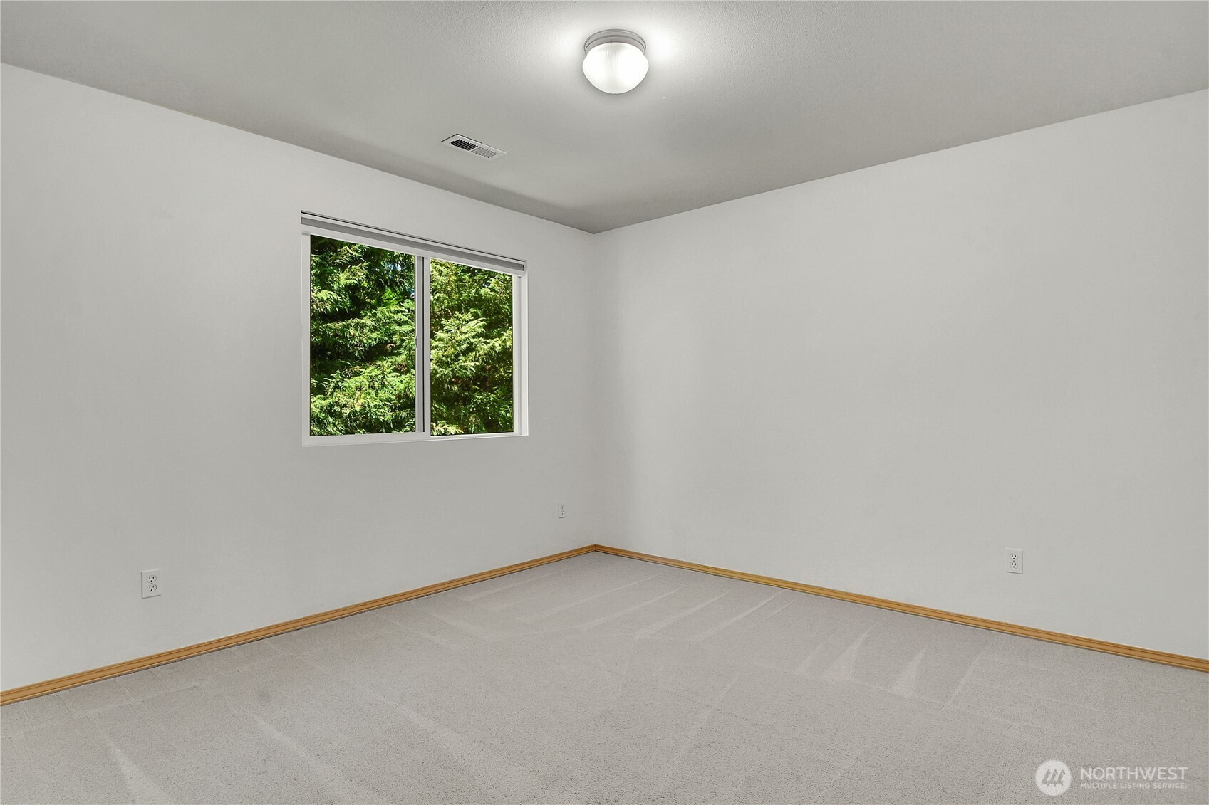 Northeast bedroom. Neutral carpet. Closet with paneled bi-fold doors. Window with screen and pulldown shade. View of Arboretum landscape.